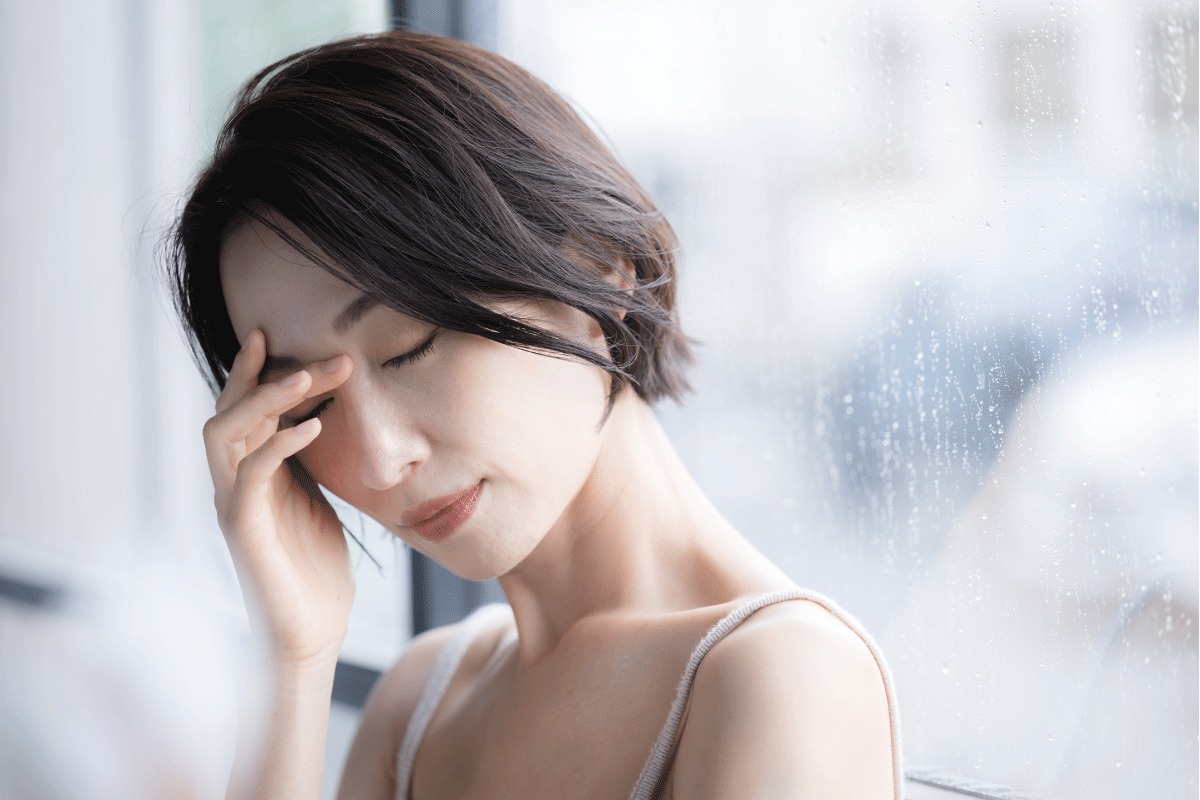 雨の日の頭痛に悩む女性