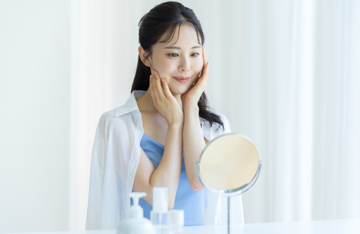 スキンケアで鏡を見る女性
